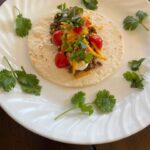 ground beef taco with tomato, cilantro, and cheese